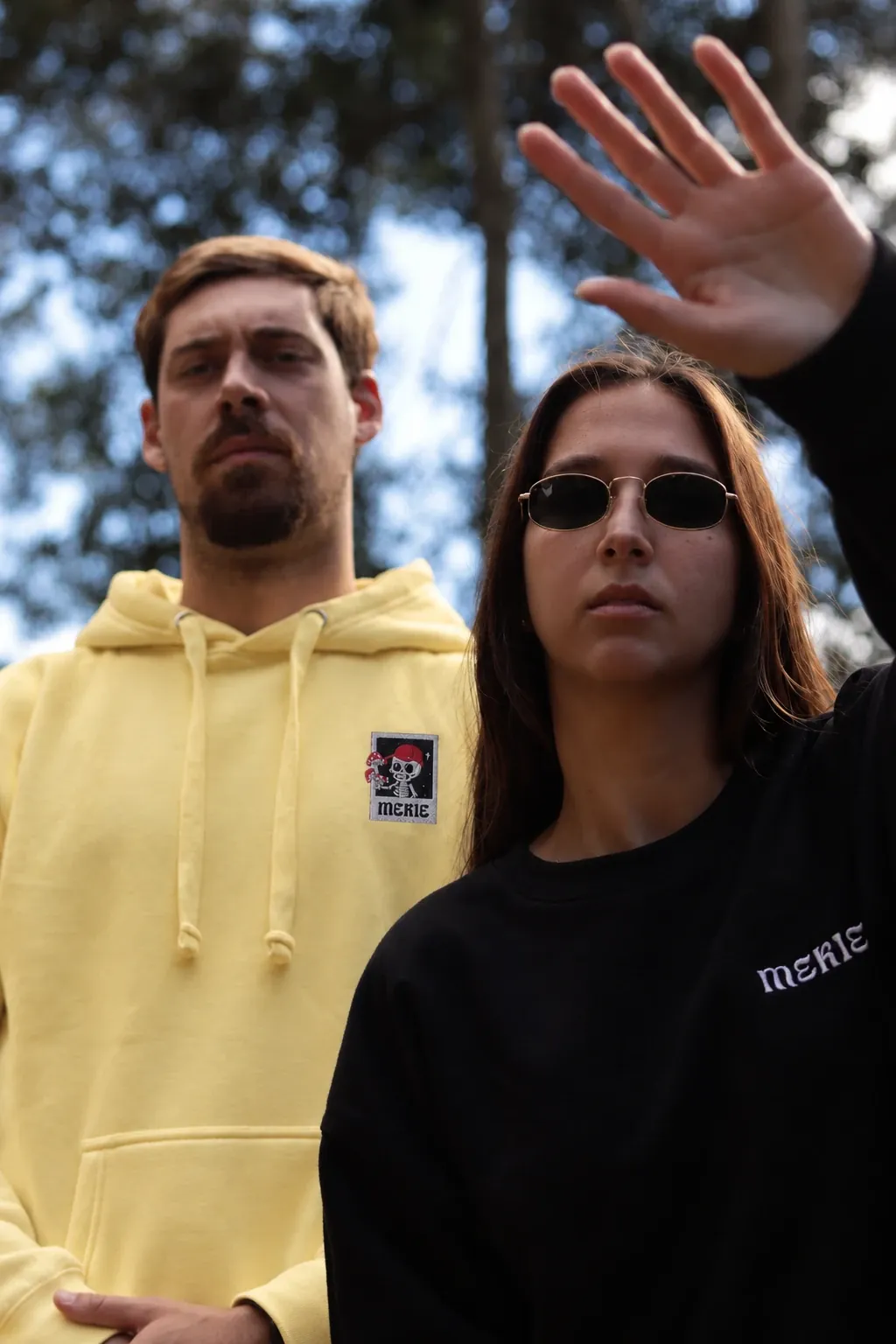 Rapaz com o hoodie Esqueleto amarelo pastel e rapariga com sweatshirt preta Mekie