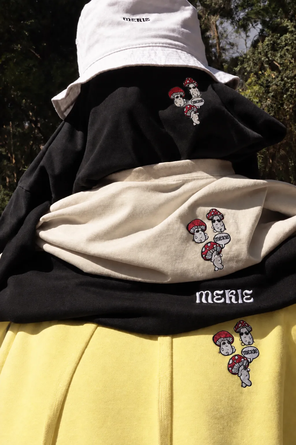 Hoodies e t-shirts Mekie com cogumelos bordados e um bucket hat, entre folhas